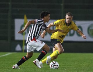 Imagem jogadores disputando a bola em campo gramado