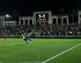 Estádio de futebol no Nordeste brasileiro com placar 1-1 em jogo da Copa do Nordeste entre Vila Nova e Náutico.