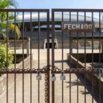 Estádio de futebol vazio em Goiânia com portões fechados, representando punição da Fifa ao Atlético-GO por dívida.