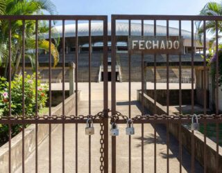Estádio de futebol vazio em Goiânia com portões fechados, representando punição da Fifa ao Atlético-GO por dívida.