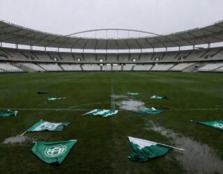 Imagem Estádio de futebol com bandeiras rasgadas no gramado