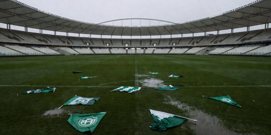 Imagem Estádio de futebol com bandeiras rasgadas no gramado