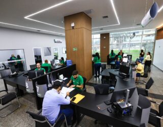 Imagem pessoas sentadas em mesa de repartição publica