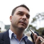 Imagem homem de terno sem gravata olhado para cima com celular a sua frente para gravar