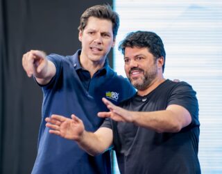 Imagem dois homens gesticulando com as mãos