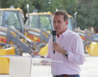 Imagem homem camisa branca segurando microfone Vanderlan entrega maquinários a 39 municípios. (Foto: Divulgação)