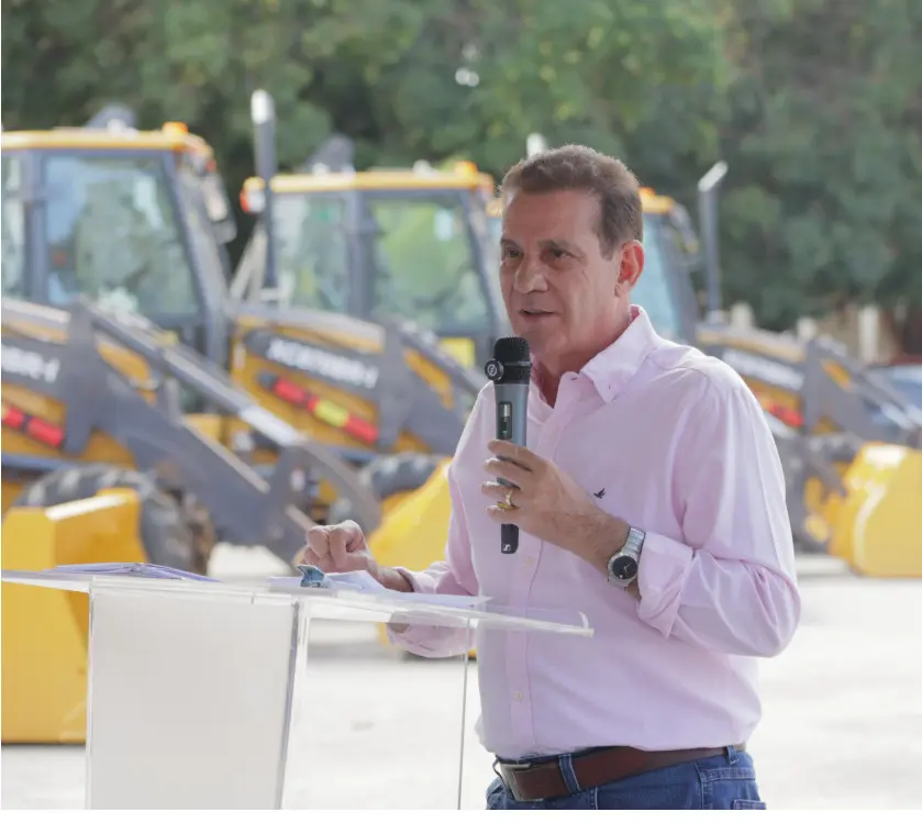 Imagem homem camisa branca segurando microfone Vanderlan entrega maquinários a 39 municípios. (Foto: Divulgação)