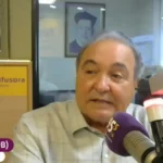 Imagem homem calvo falando em microfone de rádio