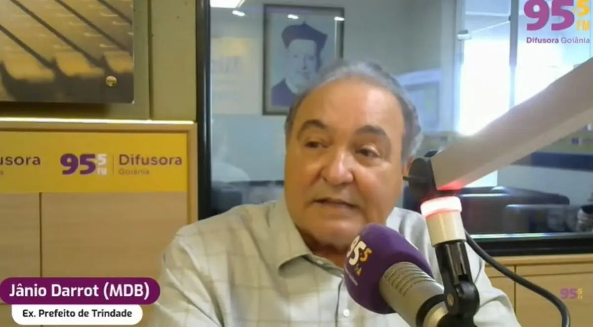 Imagem homem calvo falando em microfone de rádio