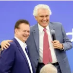 Imagem dois homens de terno e gravata sorrindo