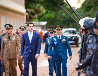 Imagem homem de terno caminhado ao lado de policiais