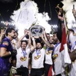 Imagem jogadores comemorando titulo com taça