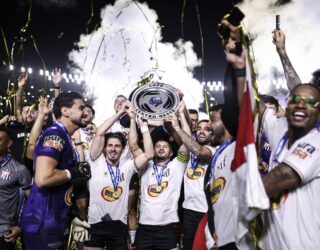 Imagem jogadores comemorando titulo com taça
