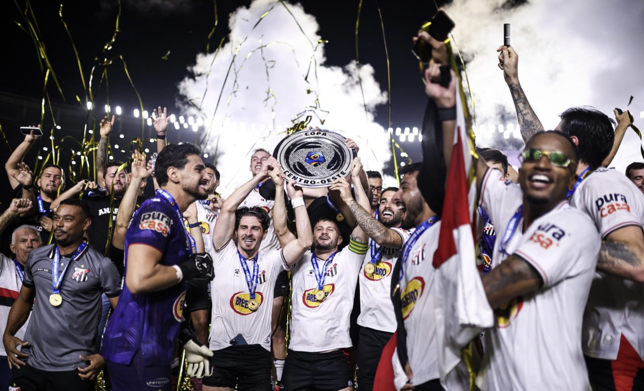 Imagem jogadores comemorando titulo com taça