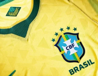 Imagem camisa amarela com detalhes verdes e cinco estrelas sobre o escudo Camisa Seleção Brasileira