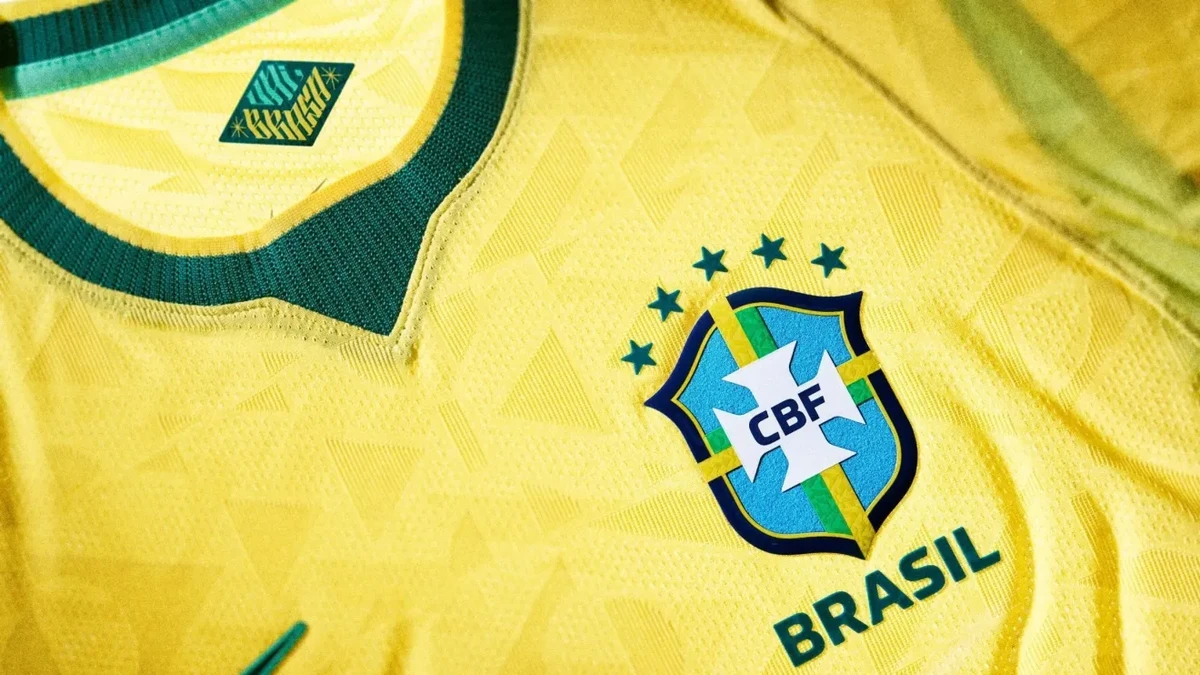 Imagem camisa amarela com detalhes verdes e cinco estrelas sobre o escudo Camisa Seleção Brasileira