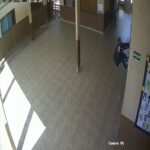 Imagem homem pendurado em grade de escola