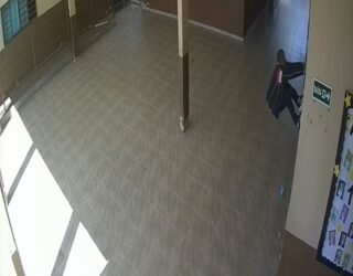 Imagem homem pendurado em grade de escola