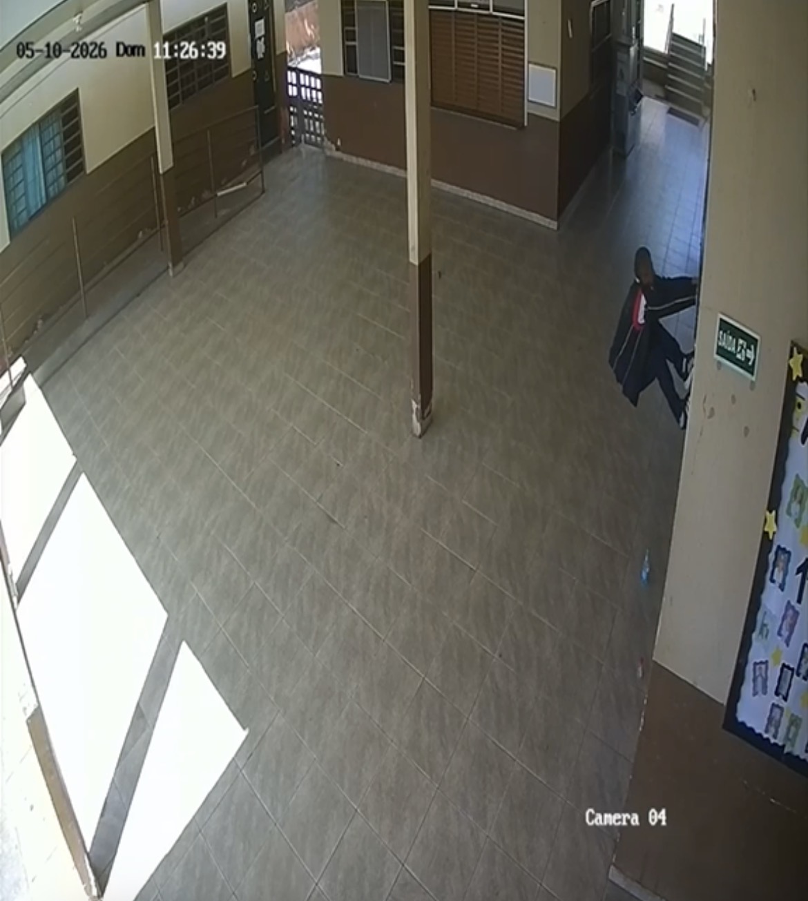 Imagem homem pendurado em grade de escola