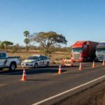 Operação de fiscalização autua veículos por irregularidades no transporte no Daia, Anápolis, com viaturas policiais e caminhões parados.