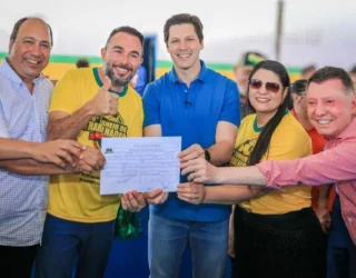 Imagem pessoas segurando um documento e sorrindo para foto