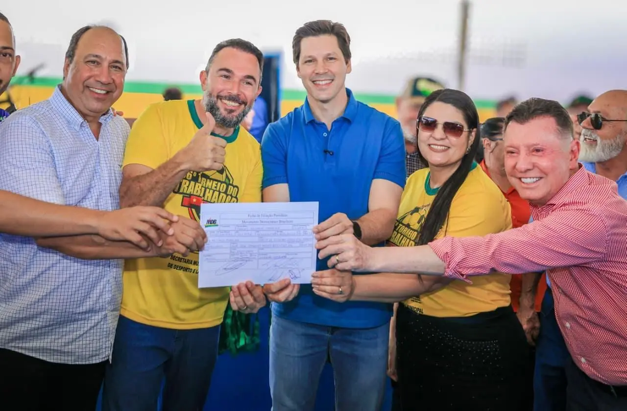 Imagem pessoas segurando um documento e sorrindo para foto