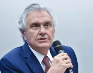 Imagem homem de terno segurando microfone com a mão