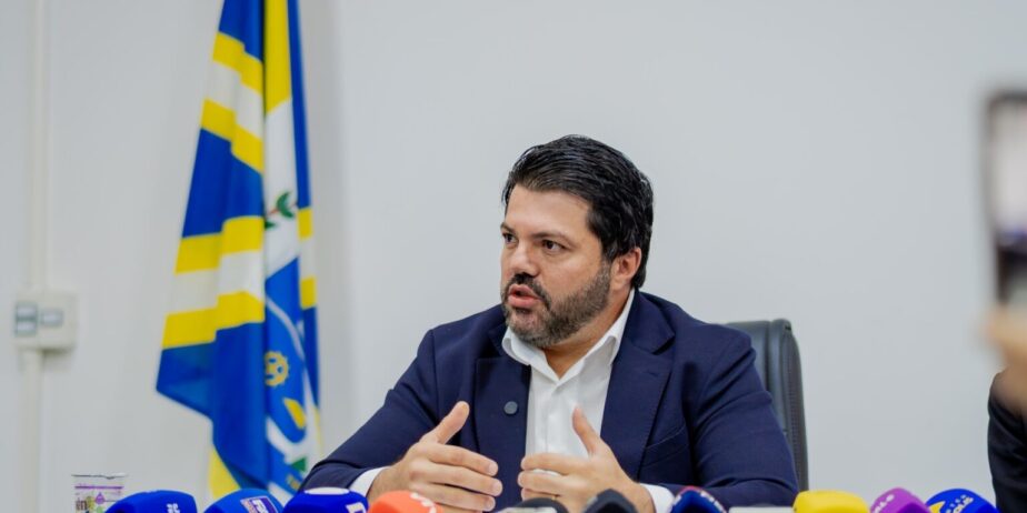 Imagem homem de terno em frente vários microfones