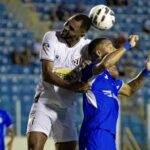 Imagem jogador de branco e azul disputando a bola no alto