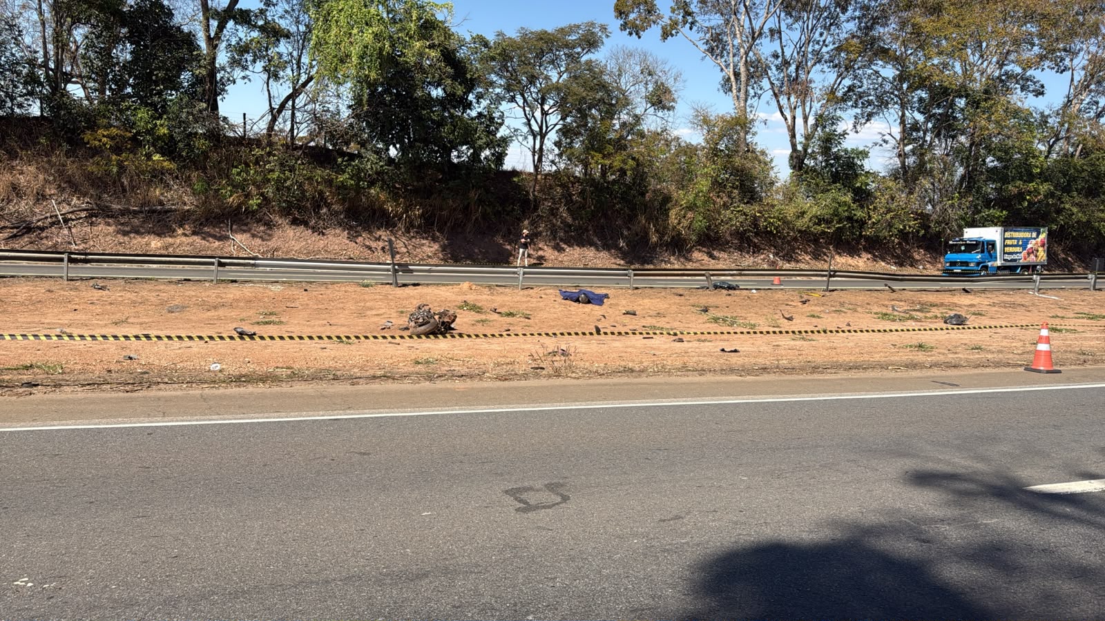 Imagem rodovia interditada ao centro motocicleta caida