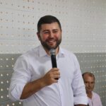 Imagedm homem de camisa branca segurando microfone sorrindo