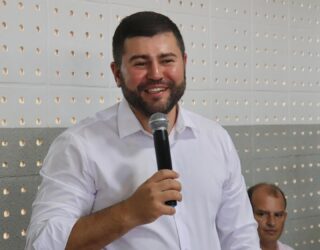 Imagedm homem de camisa branca segurando microfone sorrindo