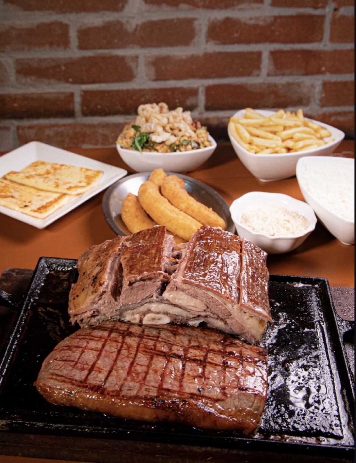 Imagem costela bovina e acompanhamentos na mesa