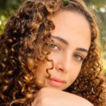 Imagem mulher cabelo cacheado com a mão no rosto