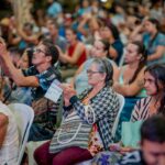 Imagem várias pessoas sentadas na plateia