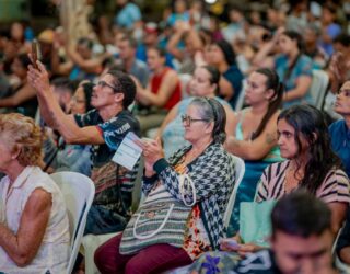 Imagem várias pessoas sentadas na plateia