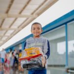 Imagem de uma criança sorrindo, segurando um brinquedo.