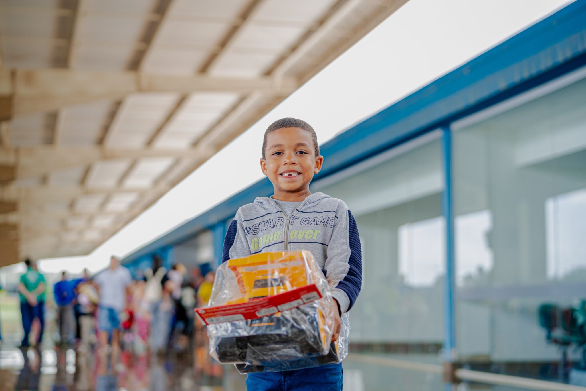 Imagem de uma criança sorrindo, segurando um brinquedo.