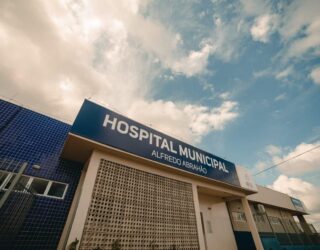 Imagem da fachada do Hospital Alfredo Abraão. Céu azul com nuvens brancas acima.