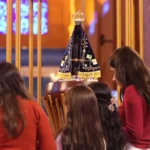 Imagem de Nossa Senhora Aparecida, rodeada por crianças.