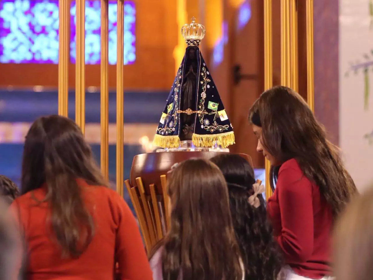 Imagem de Nossa Senhora Aparecida, rodeada por crianças.