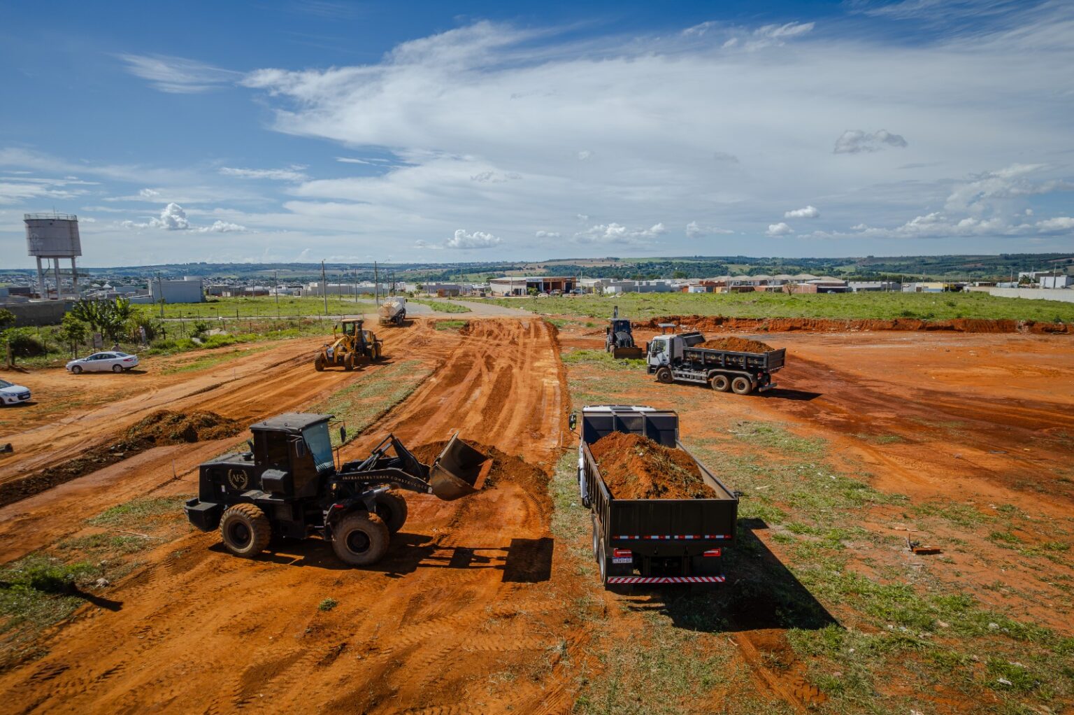 Imagem maquinas em canteiro de obras, terra e inicio de pavimentação asfaltica