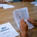 Imagem mãos segurando folha de papel Sorteio da Nota Fiscal Goiana