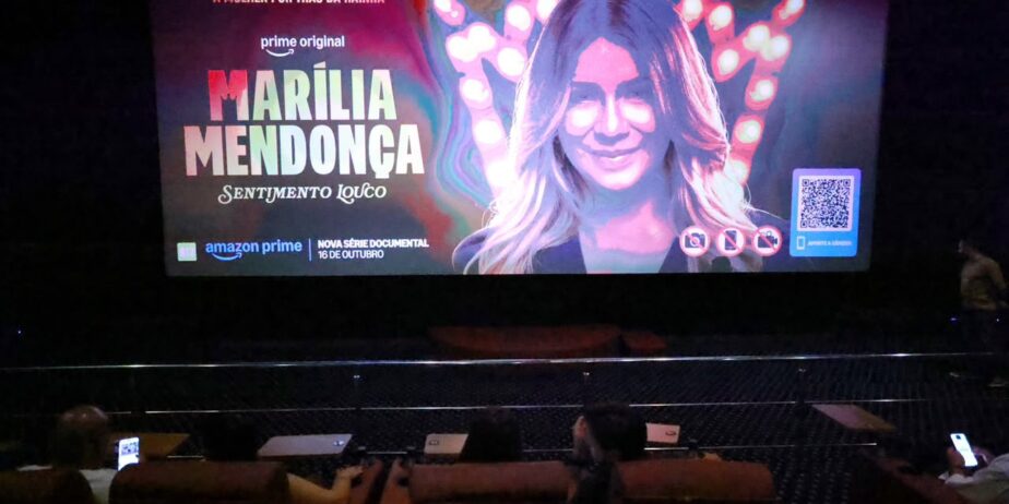 Imagem de um telão, onde mostra a capa da série documental de Marília Mendonça.