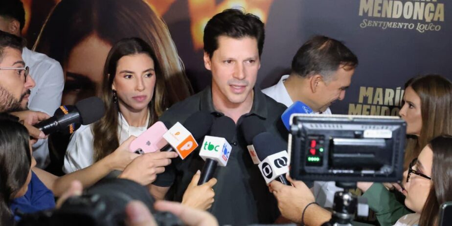 Imagem do governador Daniel Vilela, falando com jornalistas, ao lado sua esposa.