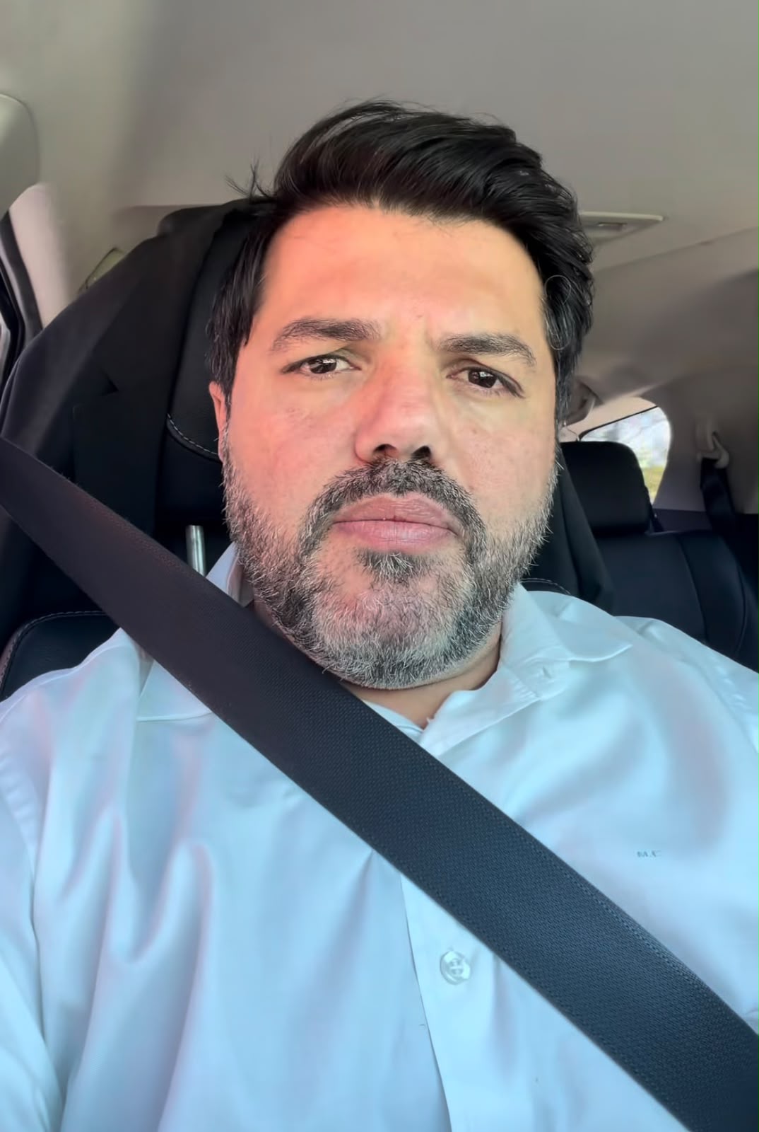 Imagem do Prefeito Márcio Corrêa, usando camisa azul clara, dentro do carro, o cinto de segurança transpassado.