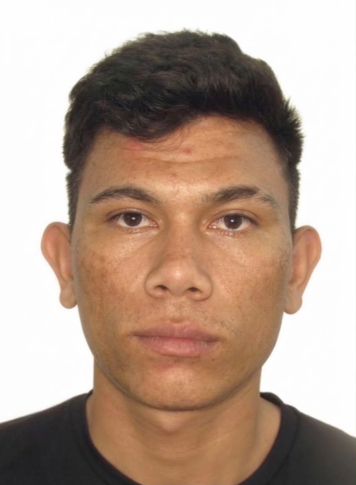 Imagem de um homem olhando para a foto, usando camiseta preta e com o fundo branco.