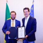Imagem do Governador Daniel Vilela ao lado de Bruno Peixoto, ambos usando terno azul.